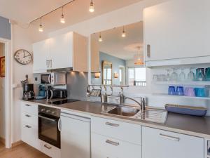 a kitchen with white cabinets and a sink at Apartment La Bizontine by Interhome in Cabourg