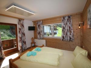 1 dormitorio con cama y ventana en Apartment Kröll by Interhome en Aschau