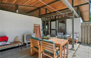 patio z drewnianym stołem i krzesłami w obiekcie Amazing Home In Korsr With Kitchen w mieście Korsør
