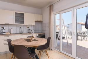 cocina con mesa y sillas y balcón en Apartment Planikovica en Trogir