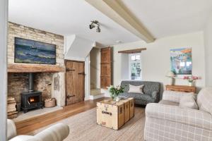 a living room with a couch and a fireplace at Coombers Mead Cottage in Tetbury