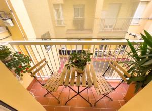 einen Balkon mit einem Tisch, Stühlen und Pflanzen in der Unterkunft Como en casa in Málaga