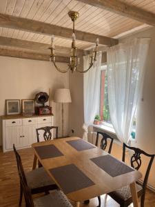 a dining room table with chairs and a chandelier at Vellior Residence in Jūrmala