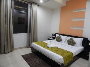 ein Schlafzimmer mit einem Bett und einem Fenster in der Unterkunft Hotel The Marque Mathura in Mathura + 27 Fotos