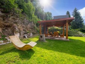 a chair sitting in the grass in front of a cabin at Chalet Mrklov by Interhome in Mrklov