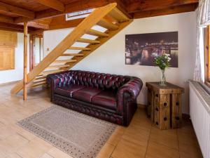 a leather couch in a living room with a staircase at Chalet Mrklov by Interhome in Mrklov