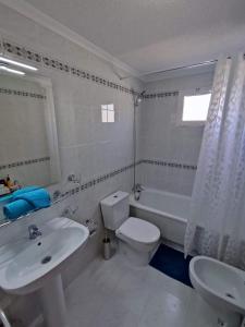 La salle de bains blanche est pourvue d'un lavabo, de toilettes et d'une baignoire. dans l'établissement Sunny Apartment Costa Blanca, à La Mata