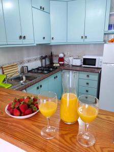 dos vasos de zumo de naranja y un bol de fruta en la encimera de la cocina en Sunny Apartment Costa Blanca, en La Mata