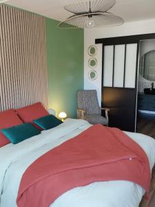 1 dormitorio con 1 cama grande con almohadas rojas y azules en appartement au coeur de Paimpol, en Paimpol
