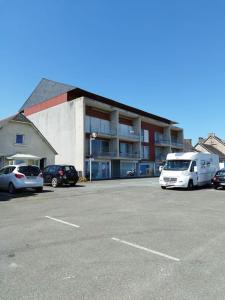 un estacionamiento con una furgoneta blanca estacionada frente a un edificio en appartement au coeur de Paimpol, en Paimpol