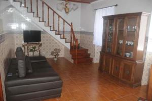 a living room with a couch and a staircase at Residência Teresinha in Povoação