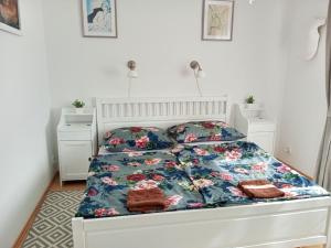 a bedroom with a white bed with a floral bedspread at Holiday Home Řevnice by Interhome in Řevnice