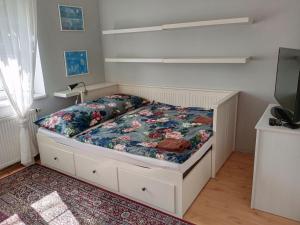 a small bedroom with a bed with a floral bedspread at Holiday Home Řevnice by Interhome in Řevnice