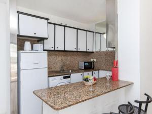 een keuken met witte kasten en een granieten aanrecht bij Apartment Riviera Park-4 by Interhome in Salou