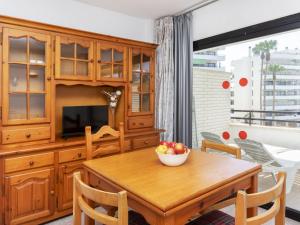 een eetkamer met een houten tafel en een fruitschaal bij Apartment Riviera Park-4 by Interhome in Salou