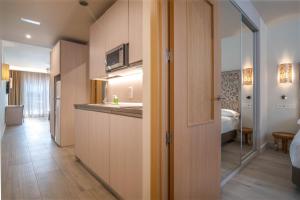 Aljarafe Suites by QHotels في Gelves: غرفة مع مطبخ وغرفة نوم