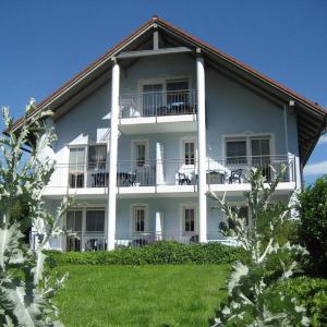 a large white building with tables on the balcony at Appartementhaus am Brückerl in Bad Füssing