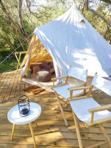Zelt mit Stühlen und Tischen auf einer Terrasse in der Unterkunft Gaia Double or Twin Bell Tent in Swellendam