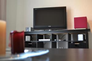a flat screen tv sitting on top of a entertainment center at Fewo Larissa in Beuron
