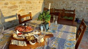 a table with a plate of food and wine glasses at Cascina Nomade in Dogliani