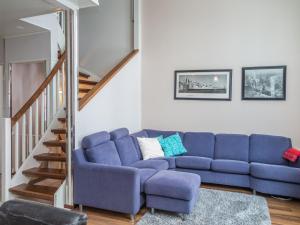 a living room with a blue couch and a staircase at Holiday Home Tahkonkallio 34 b by Interhome in Tahkovuori