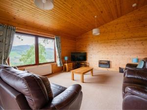 a living room with leather furniture and a large window at Holiday Home Achmony Type 2-1 by Interhome in Drumnadrochit