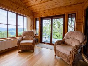 a living room with two chairs and large windows at Holiday Home Achmony Type 2-1 by Interhome in Drumnadrochit