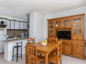 uma cozinha e sala de jantar com uma mesa de madeira e cadeiras em Apartment Riviera Park-7 by Interhome em Salou