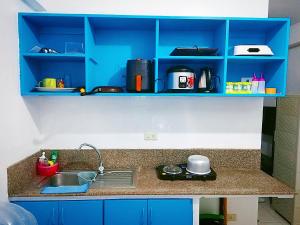 encimera de cocina con fregadero y armarios azules en Isabelle Garden Villas 429 en Manila