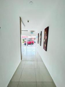 um corredor com pinturas numa parede branca em V Hotel Melaka (Near Jonker Street) em Malaca