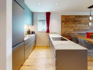 a kitchen with a counter top and a table at Apartment Uehlinger La Riva 307 by Interhome in Lenzerheide