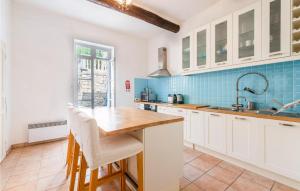 a kitchen with white cabinets and blue tiles at 4 Bedroom Gorgeous Home In Magalas in Magalas