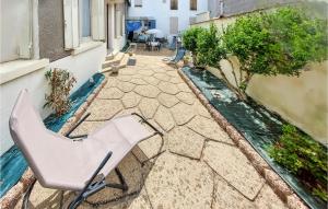 una silla sentada en una pasarela de piedra junto a un edificio en Lovely Home In Boussac With Kitchen en Boussac