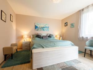 a bedroom with a large bed and a chair at Apartment Zen by Interhome in Révfülöp