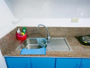 a kitchen sink with a blue towel next to it at Isabelle Garden Villas 429 in Manila