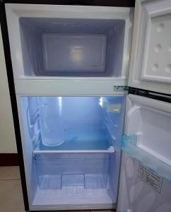 an empty refrigerator with its door open and its at Isabelle Garden Villas 429 in Manila