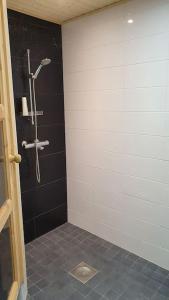 a bathroom with a shower with a black and white wall at Holiday home Villa Esteri in Pyhätunturi