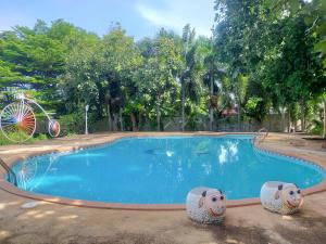 una piscina con dos estatuas de oveja al lado en High Hill Fresh Resort, en Ban Liap