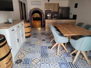 uma cozinha com uma mesa e cadeiras num piso de azulejo em Modrý sklep 77 em Velké Pavlovice