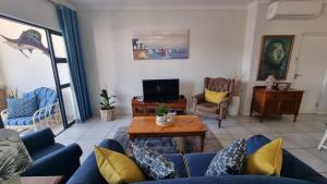 a living room with a blue couch and a table at Ballito Beach Vibes at Ballito Hills in Ballito