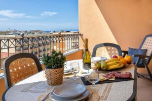 a table with a plate of fruit on a balcony at KaRol Casa Vacanze in Alghero
