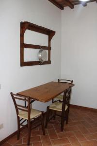 a wooden table with two chairs and a mirror at Casa dell'Ulivo in Pergognano