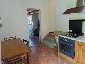 a kitchen with a stove and a table and a dining room at Casa dell'Ulivo in Pergognano