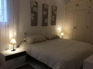 a bedroom with a large white bed with two lamps at Old town Marbella home in Marbella