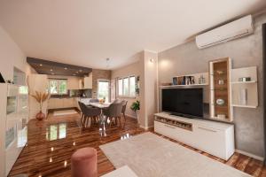 a large living room with a table and a television at Pool apartment with traditional Dalmatian Konoba in Nin