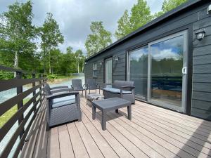 a deck with chairs and tables on a tiny house at GRAMPING STAY TOMAMU in Tomamu