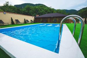 a swimming pool with blue water in a yard at La Roby si Niko in Dubova
