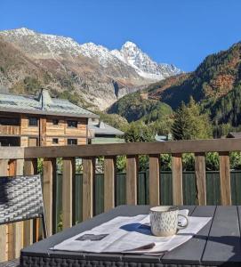 a coffee cup sitting on a table on a balcony at Les Grands Montets Family Lodge in Chamonix