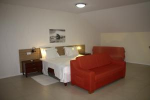 a bedroom with a bed and a red chair at Mindelo Residencial in Mindelo