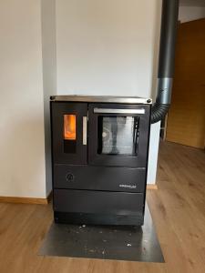 a black oven sitting on top of a floor at Center No 1 in Bad Ischl